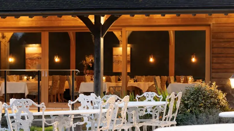 outdoor tables with wooden pillars in the background and warm light